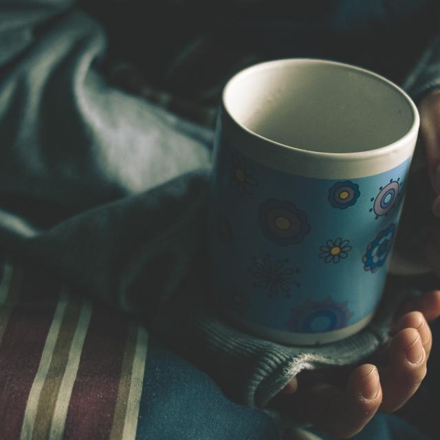 Image of a person's hands holding a coffee cup