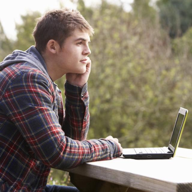 Young man sitting at a table and thinking.