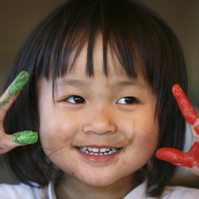 Young girl holding up her painted hands 