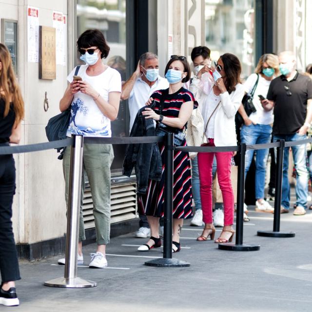 Queue of people during pandemic wearing face coverings 