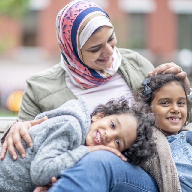 Muslim woman smiling with two children