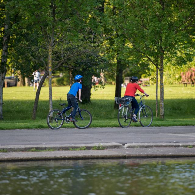 Glasgow, Scotland - Two cyclists in a park on a sunny day.