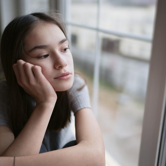 Young girl looks out of window