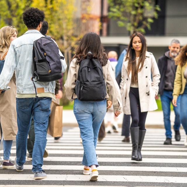 People walking across a street in different directions