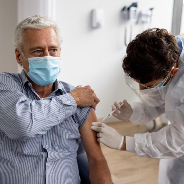 Adult man getting a COVID-19 vaccine at the hospital 