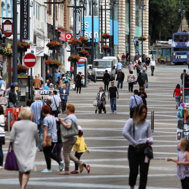 People walking in different directions on UK high street.