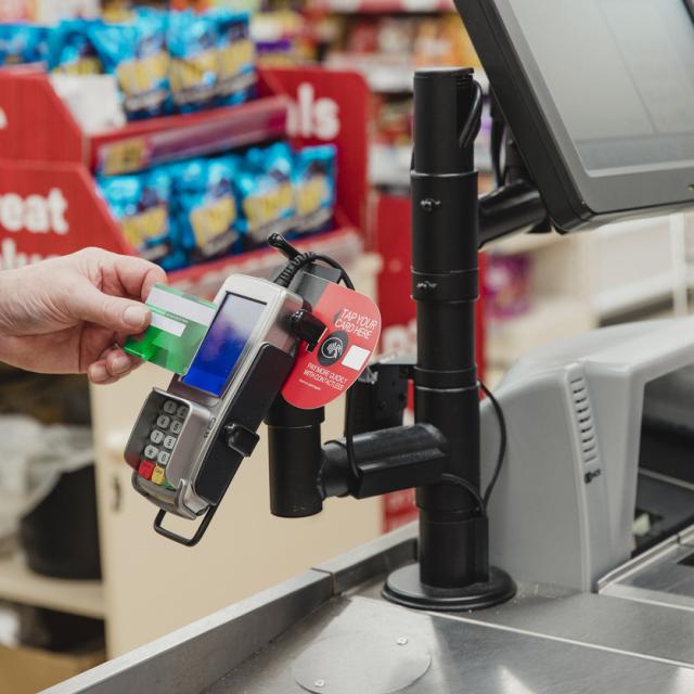 Someone paying using contactless payment in a supermarket.