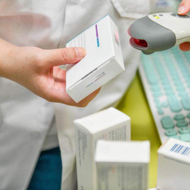 Pharmacist scanning barcode of medicine drug in a pharmacy.