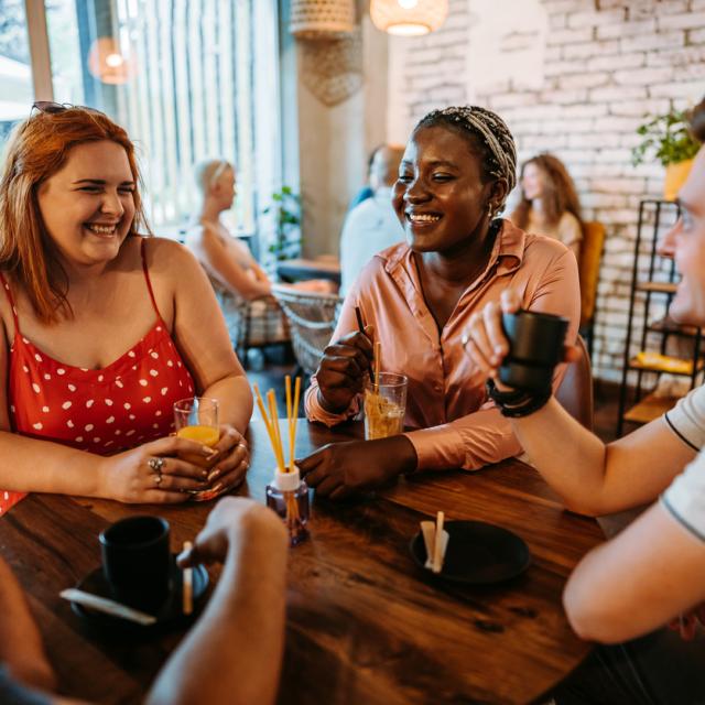 Group of young adults sitting around a table smiling