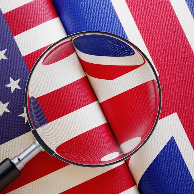 US and UK flags under a magnifying glass