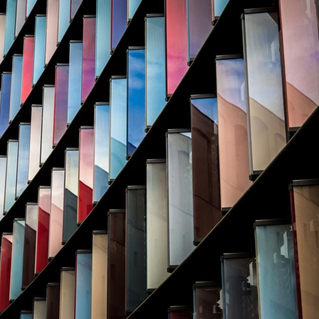 Image of building covered with glass windows and sun reflecting