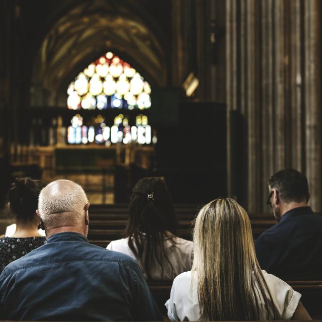 People sitting in church pews 