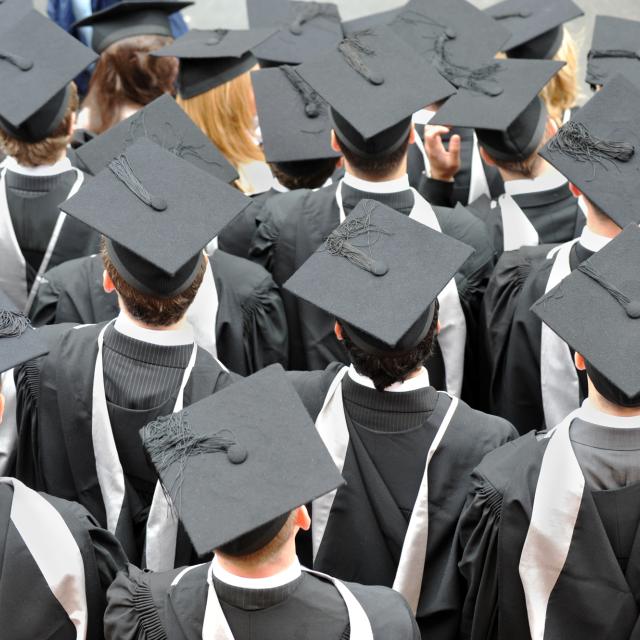 Birmingham, UK: Graduate college students photographed from above wearing traditional mortar board hats and robes at their degree ceremony