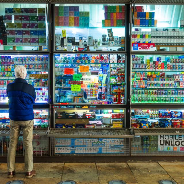 London, UK - 19 May, 2025: a senior man stands looking at a huge selection of disposable vapes at a kiosk in London, UK.