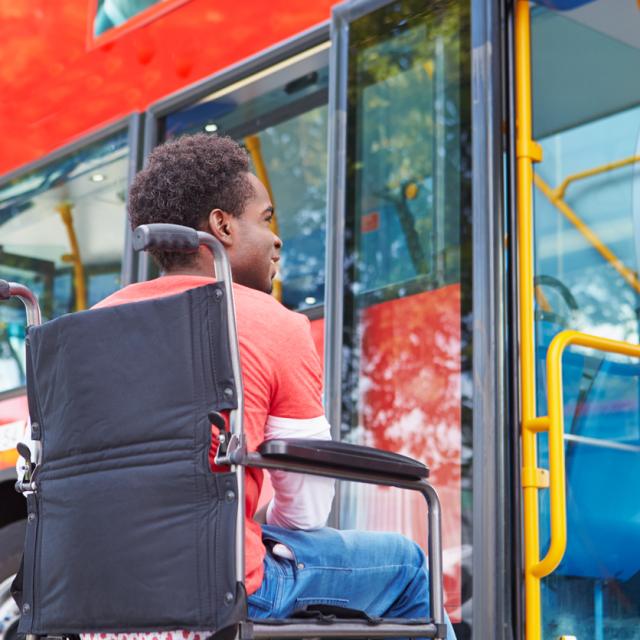 Disabled Man In Wheelchair Boarding Bus