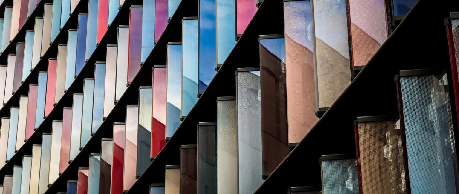 Image of building covered with glass windows and sun reflecting