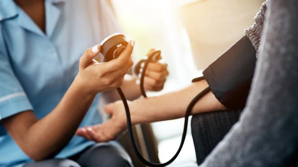 A nurse taking someone's blood pressure in the home