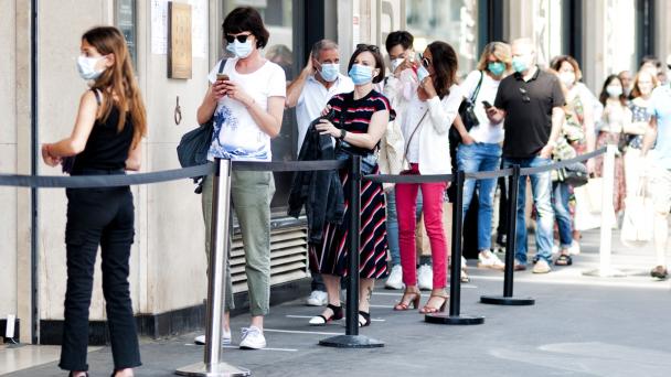 Queue of people during pandemic wearing face coverings 