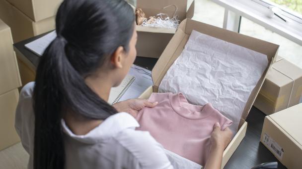 Woman boxing up clothes to sell