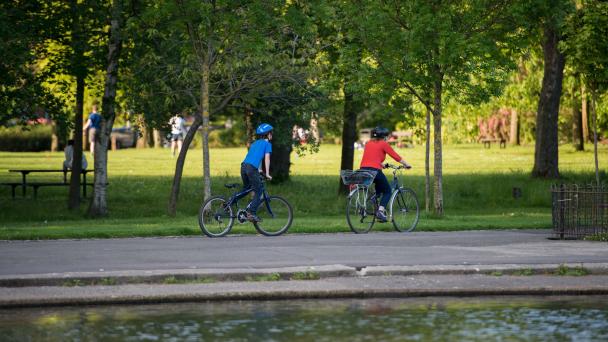 Glasgow, Scotland - Two cyclists in a park on a sunny day.