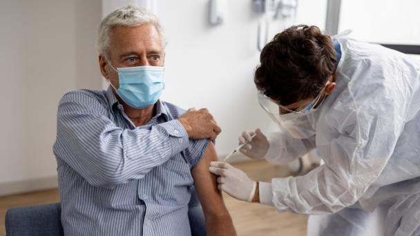 Adult man getting a COVID-19 vaccine at the hospital 
