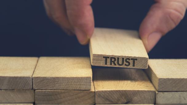 Blocks of wood, one has the word 'trust' etched on.