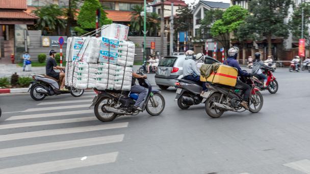 Motorbike taxi and courier riders in the heat; Hanoi, Vietnam.