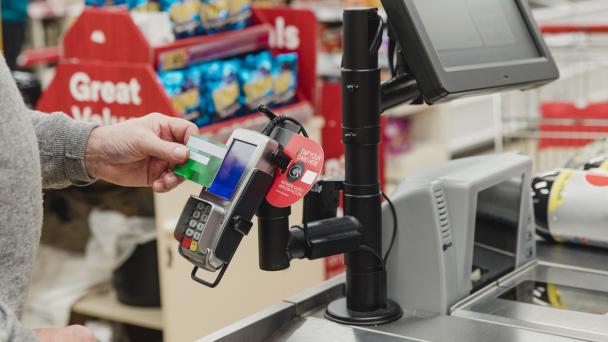 Someone paying using contactless payment in a supermarket.