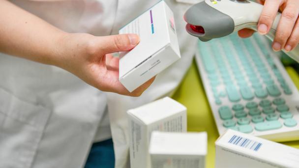 Pharmacist scanning barcode of medicine drug in a pharmacy.