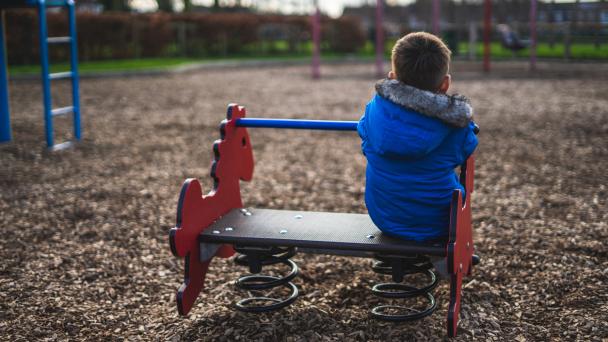 The back of a small boy playing in a park