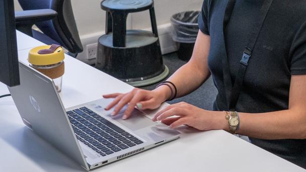 Typing at a laptop screen