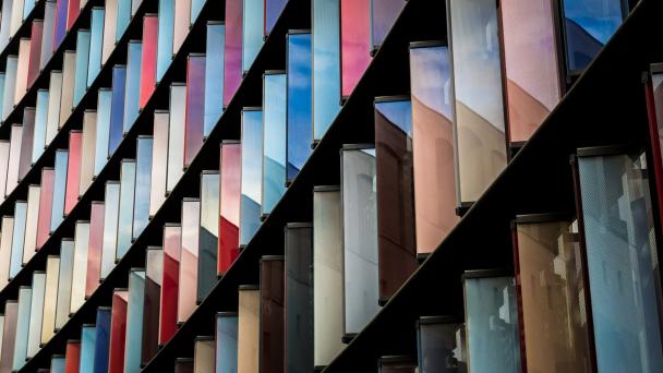 Image of building covered with glass windows and sun reflecting