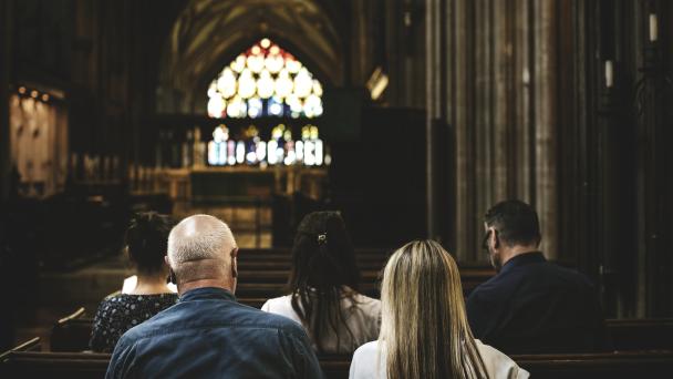 People sitting in church pews 