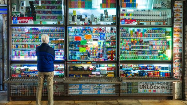London, UK - 19 May, 2025: a senior man stands looking at a huge selection of disposable vapes at a kiosk in London, UK.