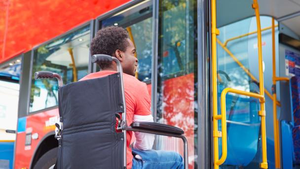 Disabled Man In Wheelchair Boarding Bus