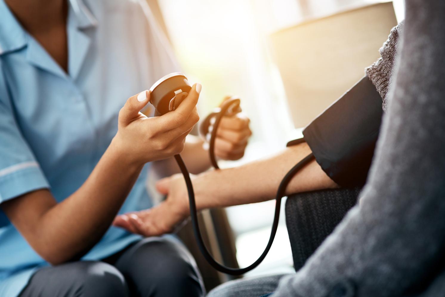 A nurse taking someone's blood pressure in the home